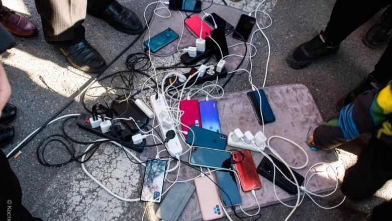 O imagine "cat o mie de cuvinte" din Herson. Ucrainenii isi incarca telefoanele la un generator in centrul orasului Imagine
