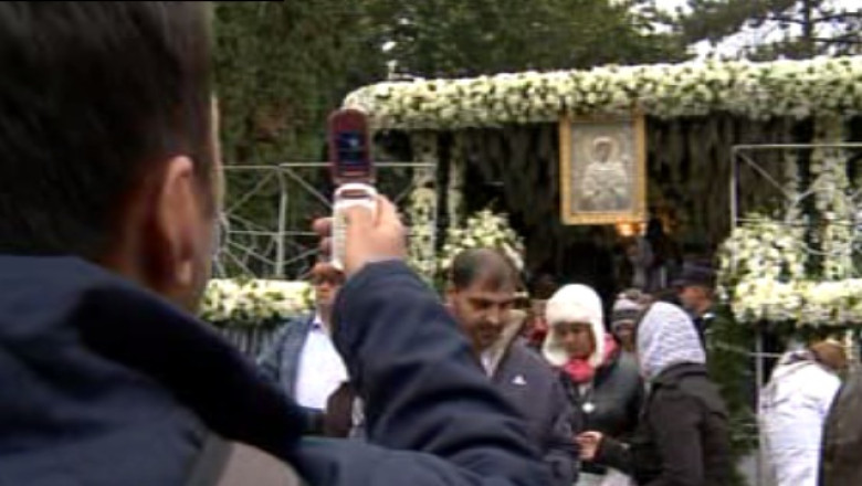 Pelerinii se pozeaza inchinandu-se la moaste Imagine