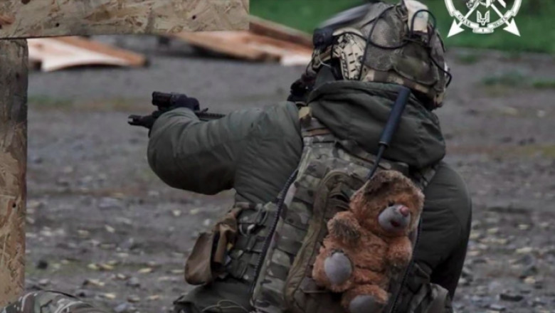 „Sa ne amintim de ce luptam”: Un soldat ucrainean poarta cu el ca talisman un ursulet de plus gasit intr-un loc de joaca bombardat Imagine