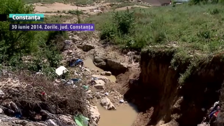 Sat, fara strazi. In localitatea Zorile, viitura a maturat si asfaltul. Au ramas cratere de 4 metri Imagine