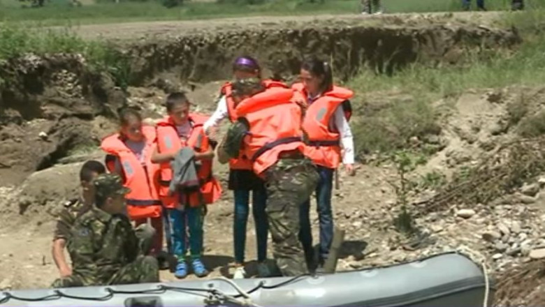 Satul fara pod. Elevii merg la scoala cu o barca pneumatica militara Imagine