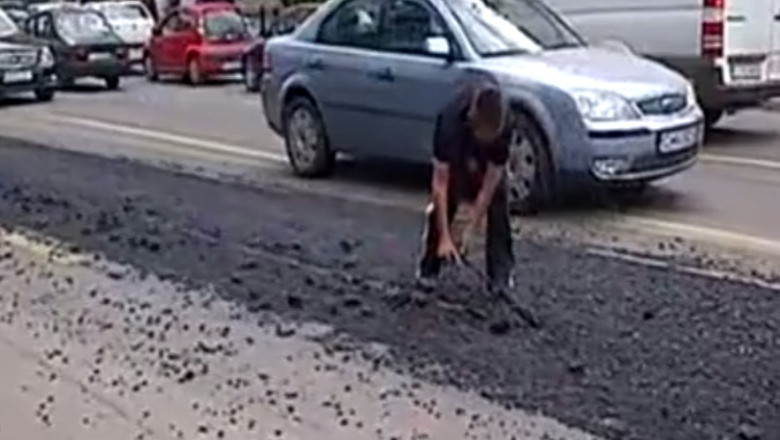 Soferul unei basculante a acoperit cu asfalt o linie de tramvai Imagine