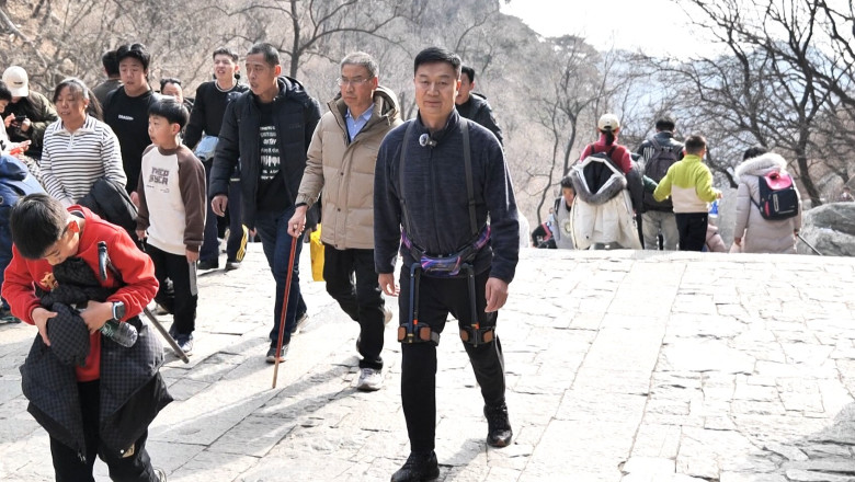 Turistii chinezi urca Muntele Tai cu ajutorul unor exoschelete robotizate Imagine
