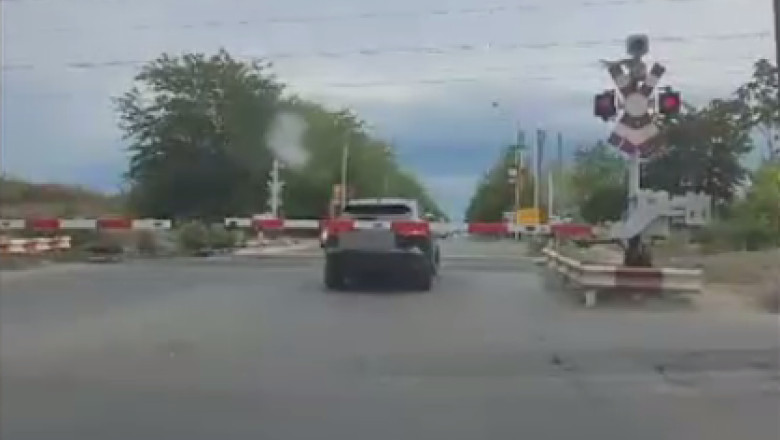 VIDEO. Un sofer a ramas blocat cu masina pe calea ferata, intre bariere Imagine